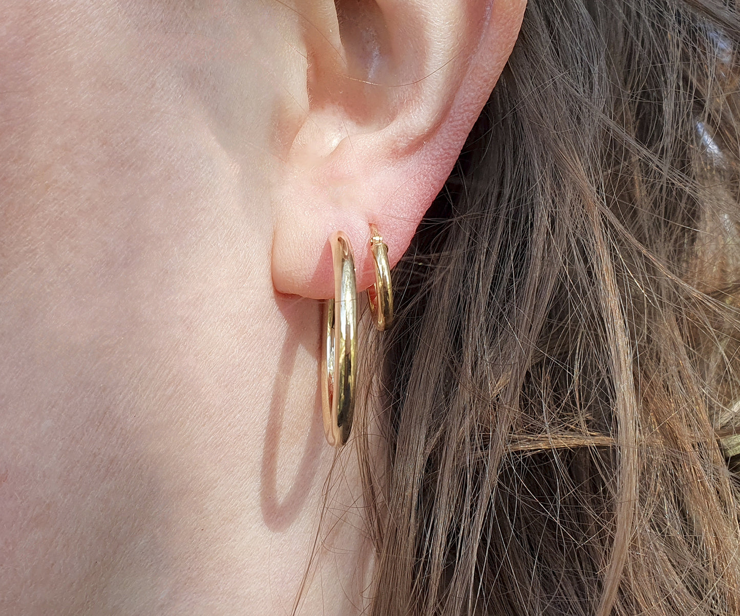 Large thick gold hoops together with simple small gold hoops
